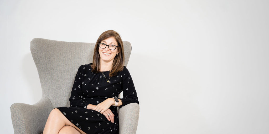 Lisa Social Medicine smiling from a chair looking at camera