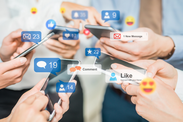 lots of hands holding phones with text messages and emojis popping out