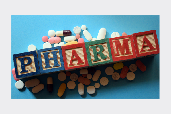 PHARMA written in building blocks with pills around it