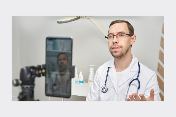 doctor speaking to a phone set up to record.